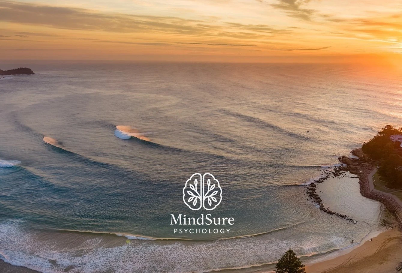 Calm sunrise over Avoca Beach with soft light on still water
