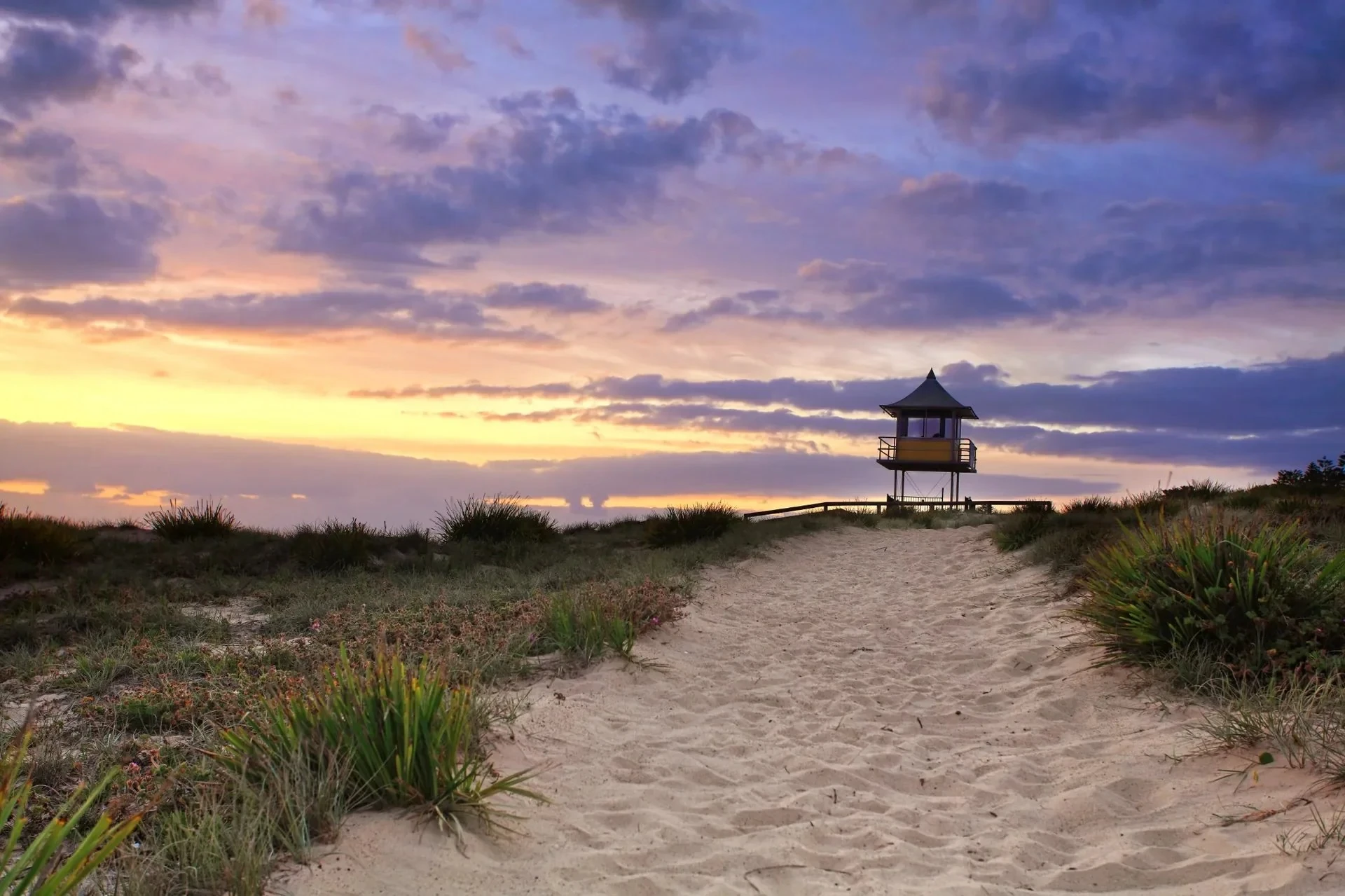 Sandy path leading to a lifeguard tower on the Central Coast at sunset