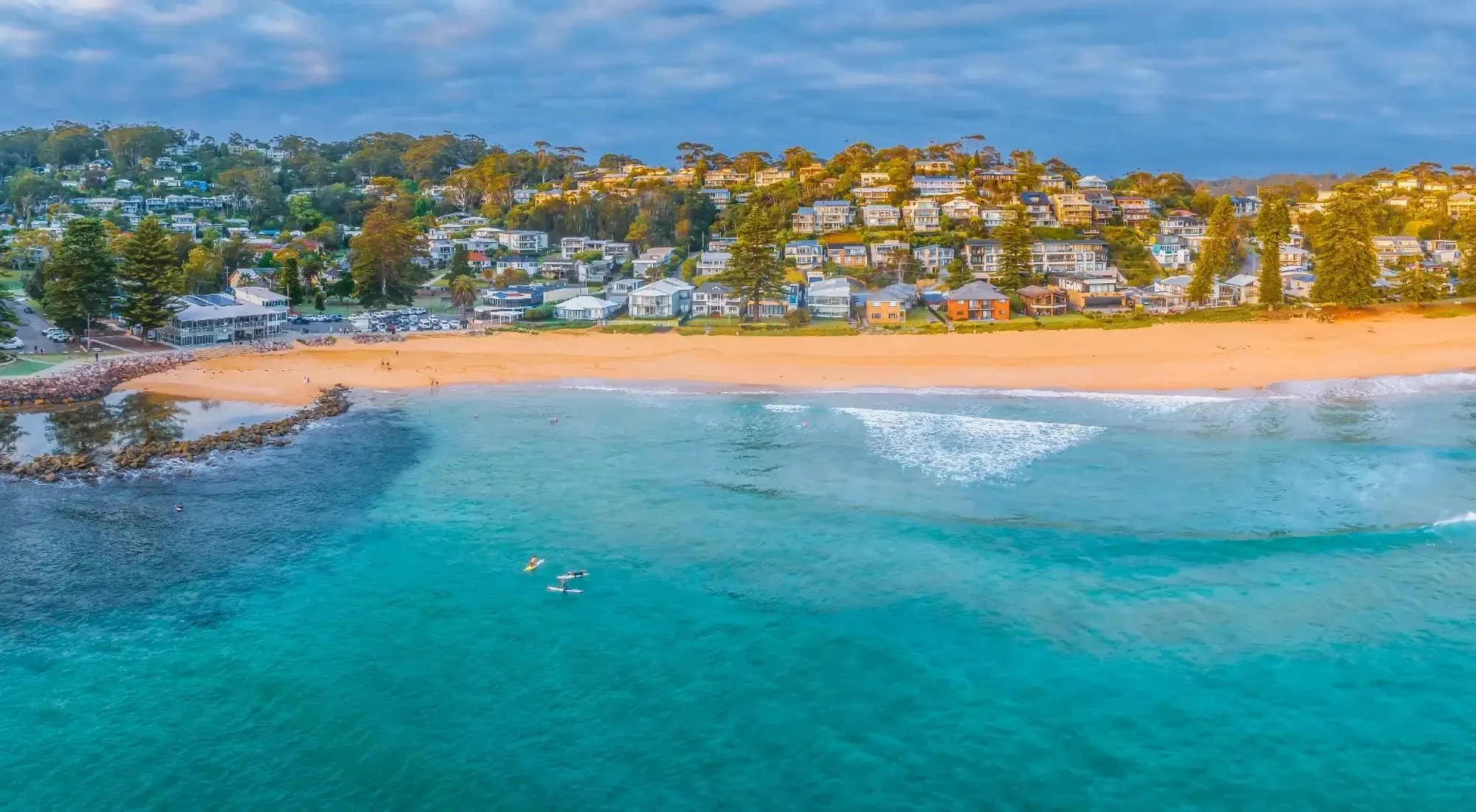 Avoca Beach viewed from the ocean looking toward the headland and houses at sunrise, Central Coast NSW