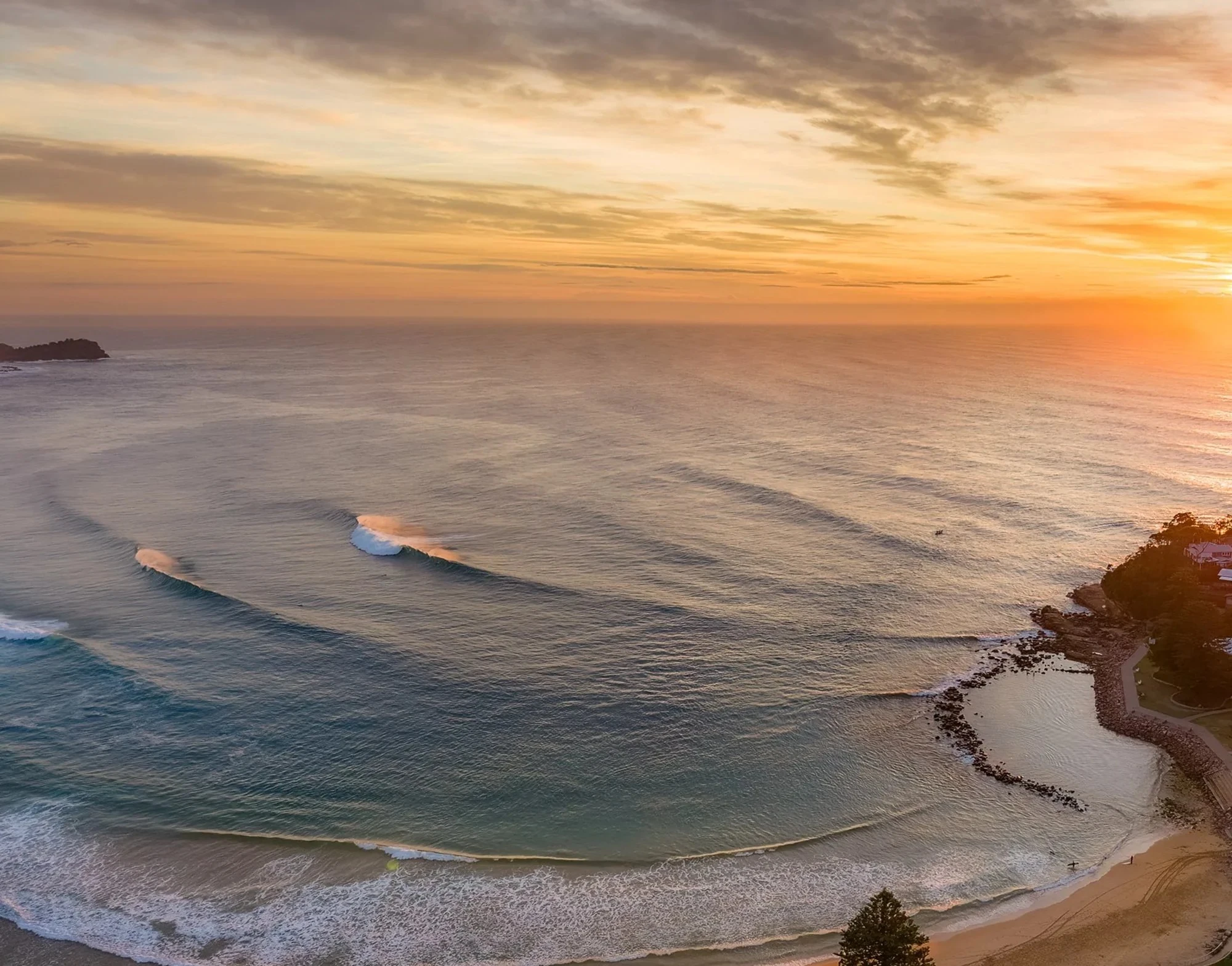 Avoca Beach sunrise aerial view with clean rolling waves and golden light, Central Coast NSW